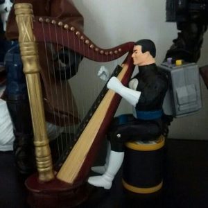Punisher wearing a backpack while playing his harp.