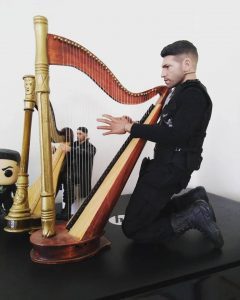 With no chair big enough for him to sit on. All I can do is have him down on his knees to the height of the 9'' harp he's playing.